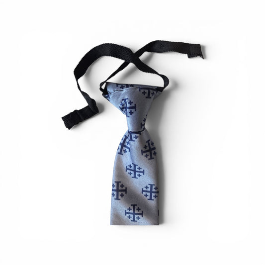 Boys Jerusalem Cross pretied necktie in silver blue with repeating navy Jerusalem Cross pattern, showing adjustable neck strap and buckle closure on white background