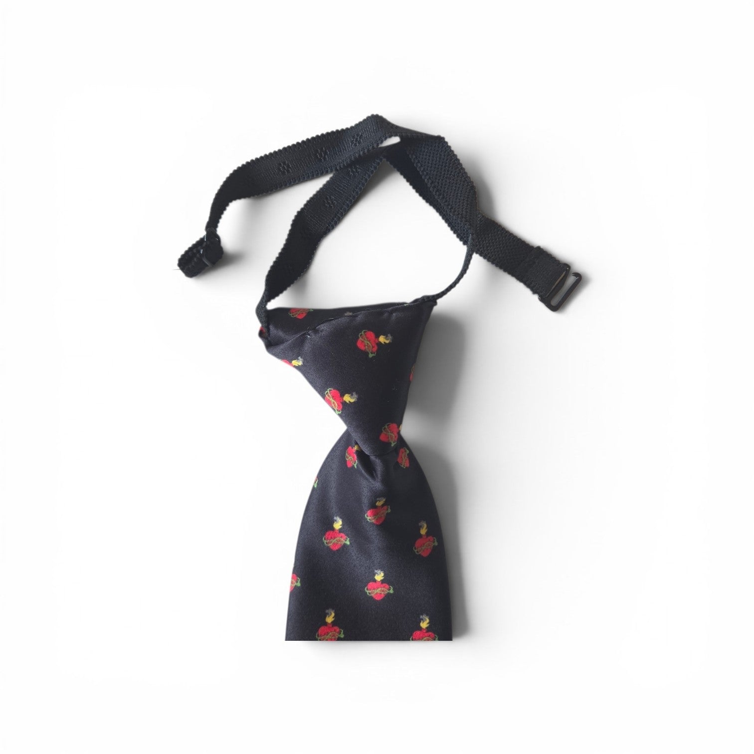 Boys Sacred Heart of Jesus pretied necktie in navy blue with repeating red Sacred Heart pattern, showing adjustable neck strap and buckle closure on white background