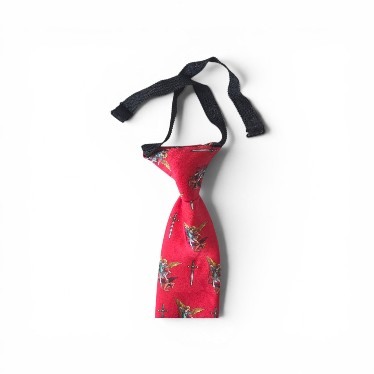 Boys St. Michael pretied necktie in red with repeating Archangel Michael and sword pattern, showing adjustable neck strap and buckle closure on white background